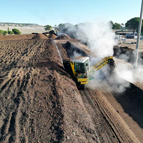 Maquinaria agrícola moviendo compost